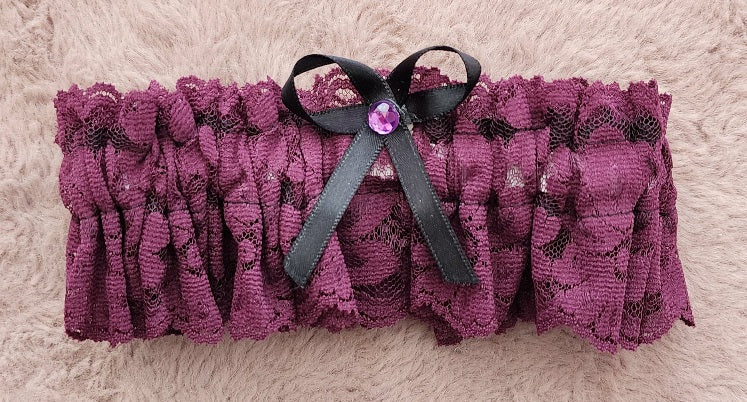 Liga color vino con lazo negro y cristal rosa